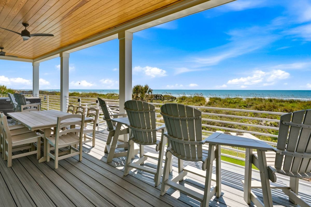 Covered oceanfront deck with dining and Adirondack seating